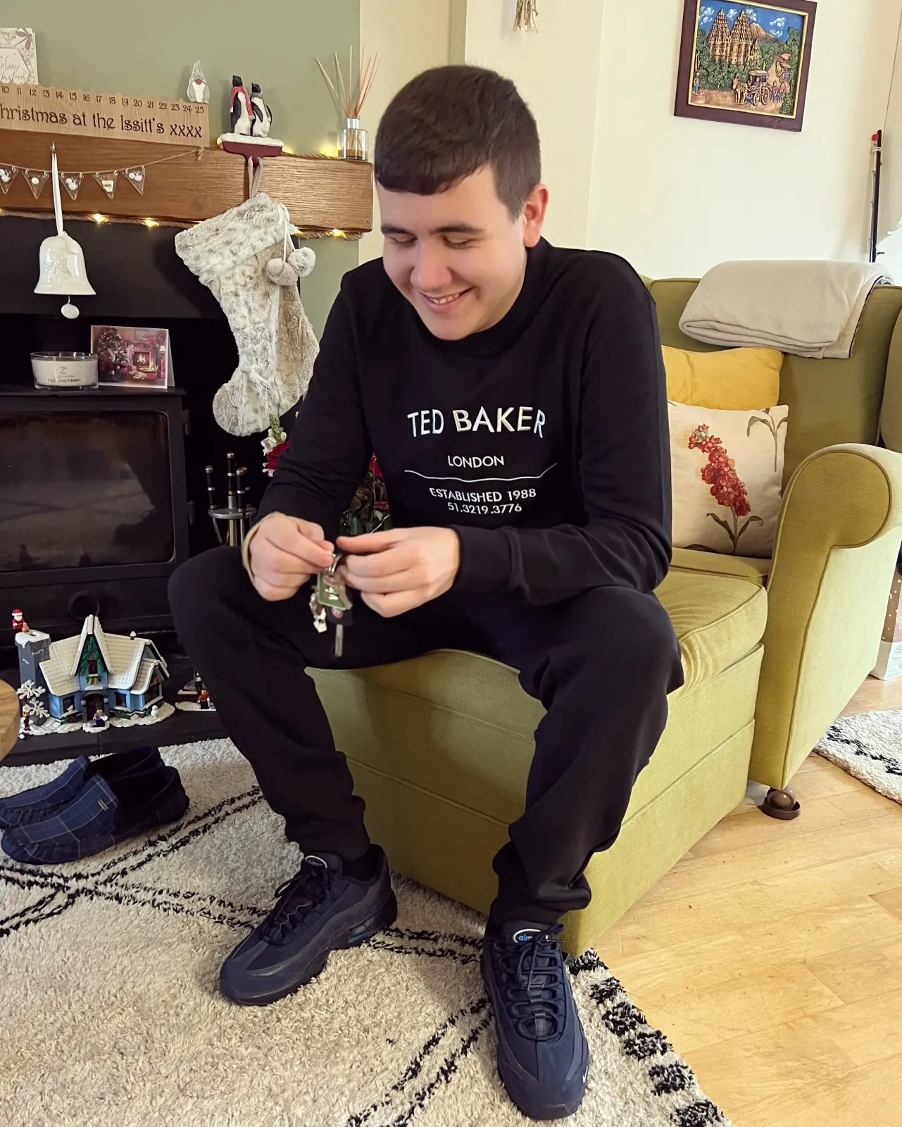 Jamie smiling at home in front of the Christmas tree.
