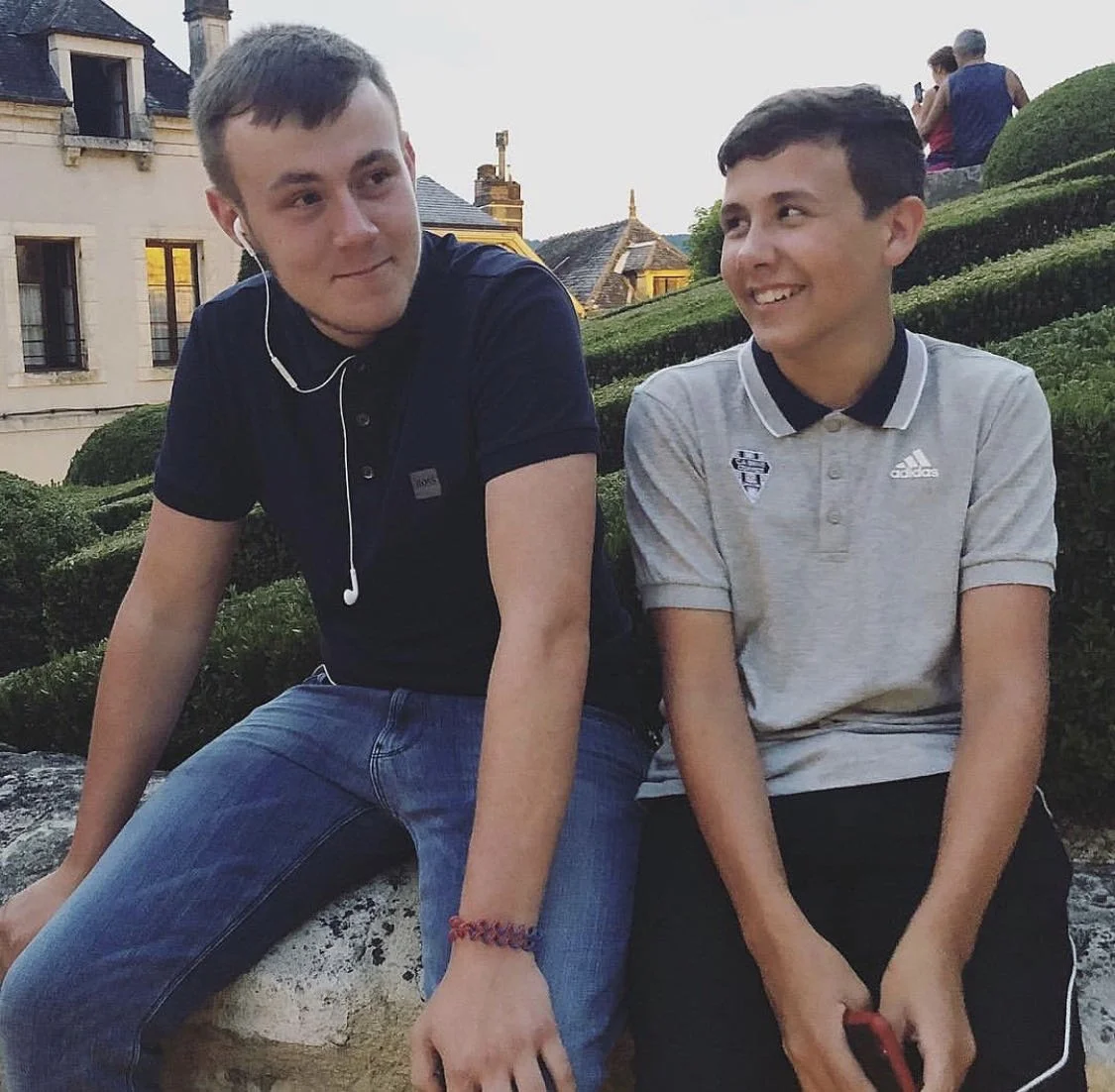 Jamie sat on a wall with his older brother Callum in the French countryside.