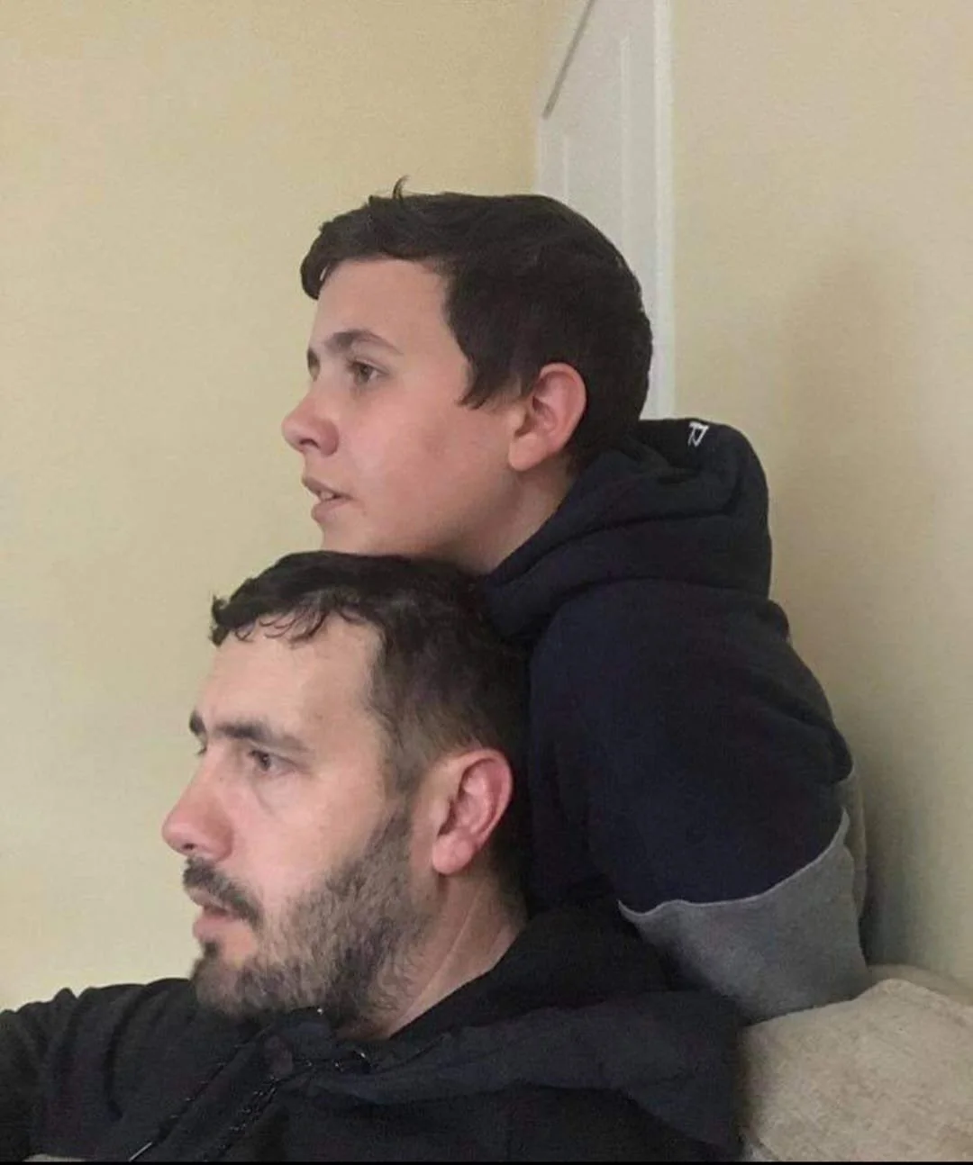 Jamie leaning over his dad on the sofa.