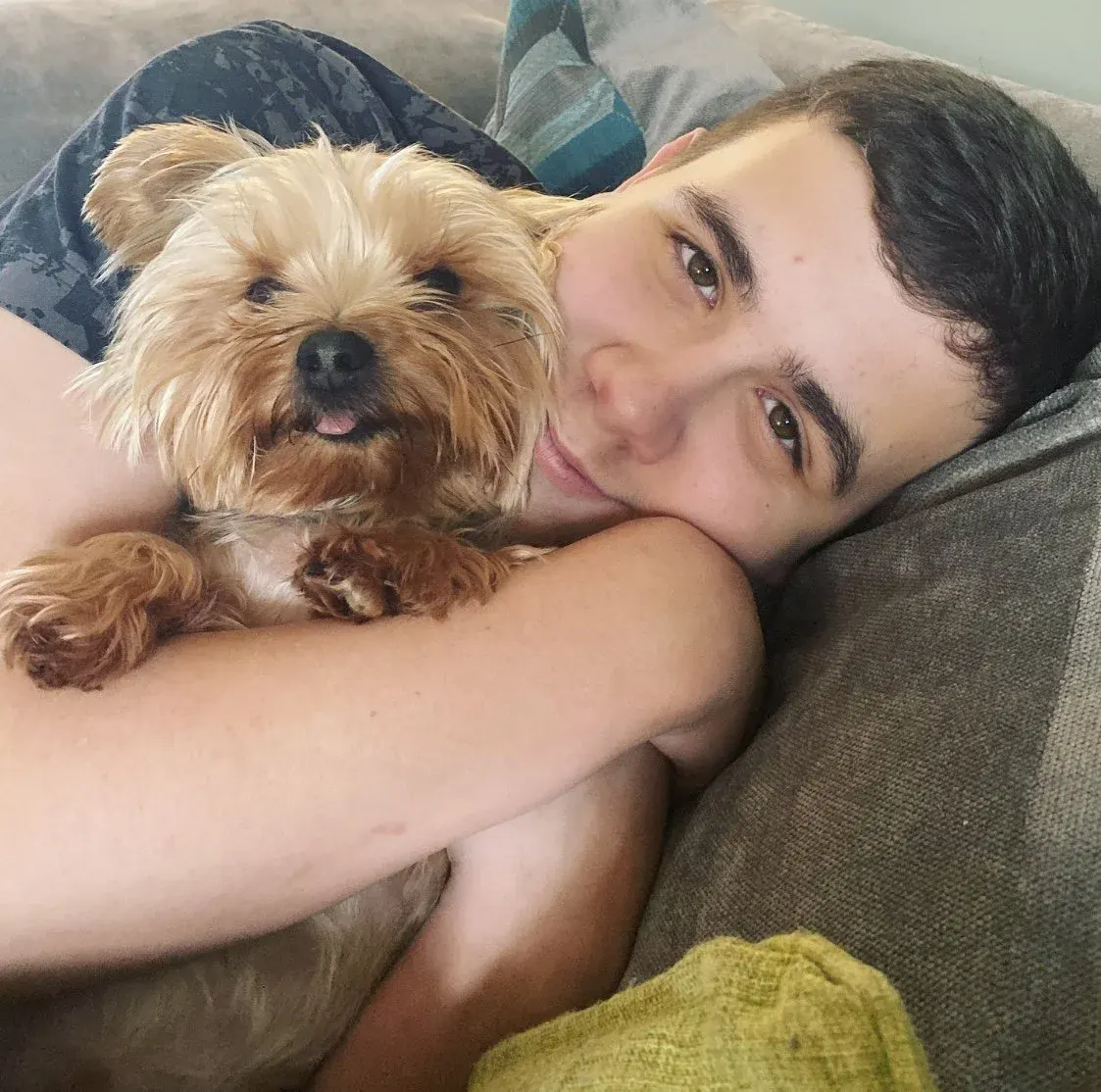 Jamie cuddled up on the sofa with his Yorkie Castro.